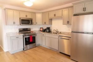 a kitchen with white cabinets and stainless steel appliances at Tranquil Retreats on Robinson in Moncton