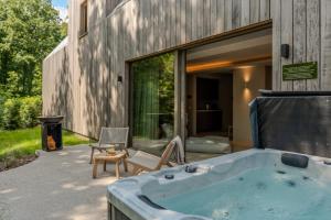a bath tub sitting outside of a house at Luxury Wellness Suite with Jacuzzi & Sauna – Woodz Lodges in Heusden - Zolder