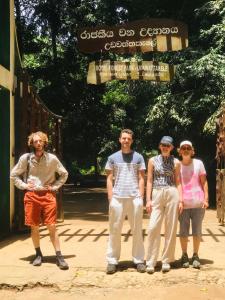 a group of people standing in front of a gate at Sapphire Homestay in Palle Deltota