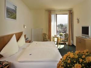 a hotel room with a bed and a table with a television at Pension Weingut Schwab in Thüngersheim