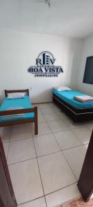 a room with two beds and a sign on the wall at Recanto Boa Vista in Joinville