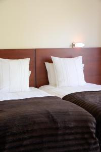 two beds with white pillows sitting next to each other at Hotel Rural Quinta Do Pego in Tabuaço