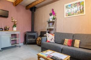 a living room with a couch and a fireplace at La forge 2/5 personnes in Saint-Pierre-de-Nogaret