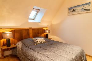 a bedroom with a bed and two lamps and a window at La forge 2/5 personnes in Saint-Pierre-de-Nogaret