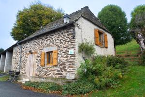 an old stone house with orange doors and windows at La forge 2/5 personnes in Saint-Pierre-de-Nogaret