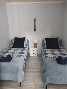 a bedroom with two beds and a night stand at Gite Les Eylauds in Pionsat