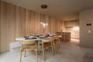 a dining room with a white table and chairs at Spacious Luxury Lodge for 8 – Woodz Lodges Heusden-Zolder in Heusden - Zolder