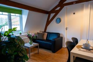 a living room with a blue couch and a table at Short Stay Wageningen in Wageningen