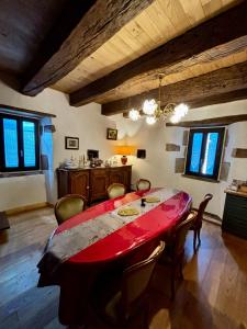 a dining room with a red table and chairs at L’Angelina in Martrin