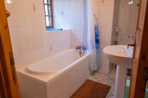 a white bathroom with a tub and a sink at Gîte agnès 2/3 personnes in Laval-du-Tarn +11 photos