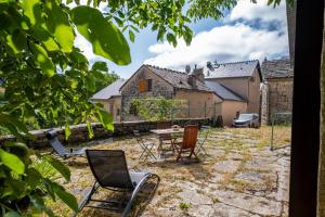 a patio with chairs and a table in a yard at Gîte agnès 2/3 personnes in Laval-du-Tarn