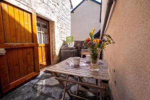 a wooden table with a vase of flowers on it at Gîte agnès 2/3 personnes in Laval-du-Tarn