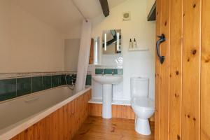 a bathroom with a sink and a tub and a toilet at Trespaddick, coastal views Treworgie Barton in Bude +28 photos