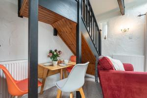a small dining room with a table and a red couch at Trespaddick, coastal views Treworgie Barton in Bude