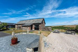 a stone house with a bench in front of it at Trespaddick, coastal views Treworgie Barton in Bude