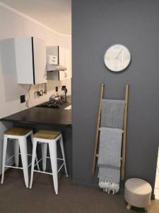 a kitchen with a counter and a clock on the wall at Place At Menlyn in Pretoria