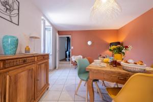 a kitchen and dining room with a table and chairs at La maison de flavie in Sainte-Cécile-dʼAndorge