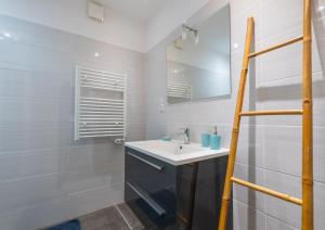 a white bathroom with a sink and a mirror at La maison de flavie in Sainte-Cécile-dʼAndorge +29 photos