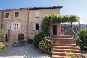 a house with stairs and flowers in front of it at La maison de flavie in Sainte-Cécile-dʼAndorge