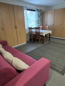 a living room with a couch and a table and chairs at Koivutie Best rooms in Ranua
