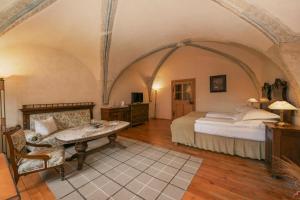 a bedroom with a bed and a table in a room at Fronius Boutique Residence in Sighişoara