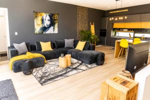 a living room with a black couch and yellow pillows at 4 Lulworth in Johannesburg