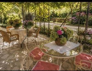 a patio with a table and chairs with potted plants at LATE Nature House Gjirokaster in Gjirokastër