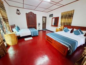 a bedroom with two beds and a red floor at Nature's Rest in Ella +164 photos