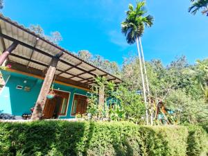 a house with a palm tree in front of it at Nature's Rest in Ella
