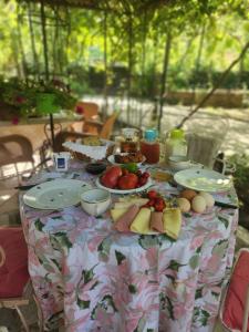 a table topped with plates of fruit on a table at LATE Nature House Gjirokaster in Gjirokastër +38 photos