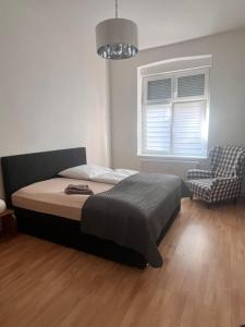 a bedroom with a bed and a chair and a window at Ferienwohnung Spremberg-City III in Spremberg