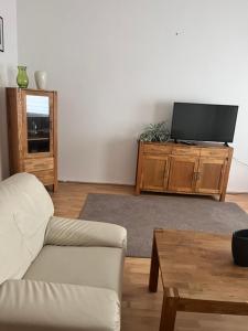 a living room with a couch and a flat screen tv at Ferienwohnung Spremberg-City III in Spremberg