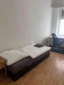 a bed in a room with a desk and a chair at Ferienwohnung Spremberg-City III in Spremberg