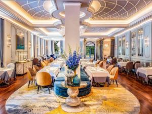 a dining room with tables and chairs and a ceiling at Sofitel Legend Metropole Hanoi in Hanoi