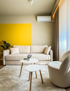 a living room with a couch and a table at All Seasons Apartments - Free Parking & City Center in Shkodër