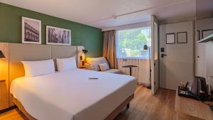 a hotel room with a large bed and a window at Campanile NATURE - Bordeaux Sud Gradignan Talence in Gradignan +43 photos
