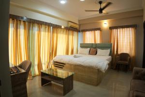 a bedroom with a bed and a living room at Hotel Alaska in Patna