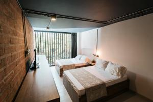 ein Hotelzimmer mit 2 Betten und einem Fenster in der Unterkunft Soy Local Provenza in Medellín