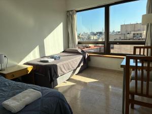 a bedroom with a bed and a large window at APART CyJ OBELISCO in Buenos Aires +10 photos