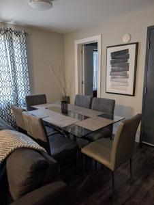 a dining room with a glass table and chairs at Clifton Hill suite 2201 in Niagara Falls +3 photos