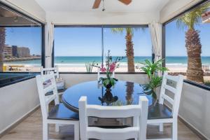 a dining room with a table and chairs and the beach at Super Beachfront Condo Ground Level on Sandy Beach in Puerto Peñasco