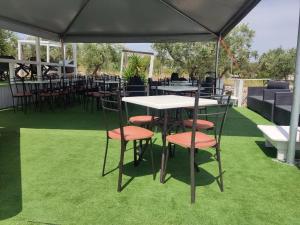 a table and chairs under a black umbrella on grass at Oasi Torre Di Mastro, Conversano in Conversano