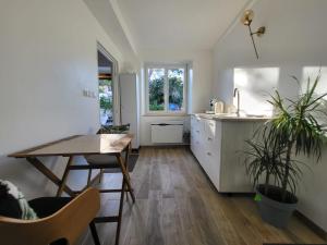 a kitchen and dining room with a table and a sink at L'Hirondelle in Fourges