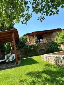 a bench sitting in the grass in a yard at Villa privata in Maremma Tuscany fontanile & wifi in Montorgiali