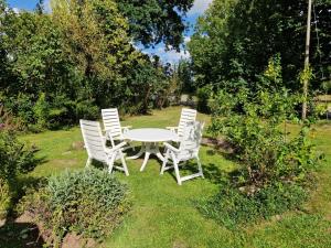 a white table and chairs in the grass at Heuler beim Ochsenturm am Deich in Dingen