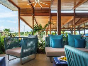 a patio with two chairs and blue pillows at Hotel Mercure Kourou Ariatel in Kourou