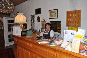 een vrouw die aan een toonbank in een winkel zit bij Hotel & Restaurant Bei Hölzchen in Hannover