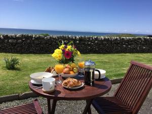 a table with food and a vase of flowers and fruit at Airyolland in Newton Stewart +15 photos