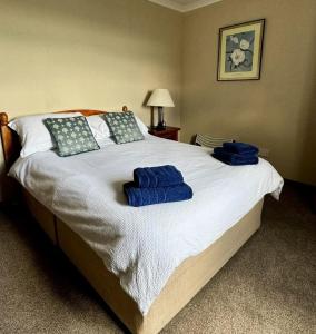 a bedroom with a large bed with blue towels on it at Airyolland in Newton Stewart