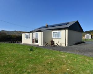 a small white house with a grass yard at Airyolland in Newton Stewart